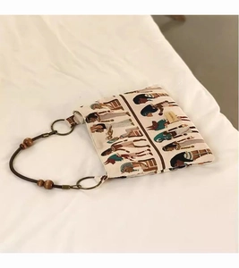 Detail of canvas tote bag featuring Egyptian jacquard pattern and wood bead handle