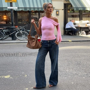 Détail du haut rose à une épaule avec liens et jean bleu à jambes larges pour femmes