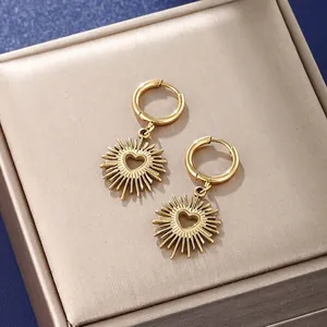 Boucles d'oreilles cœur dorées avec motif rayons de soleil sur boîte cadeau
