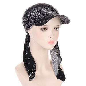Detail of black paisley print turban hat with brim and adjustable straps on mannequin head
