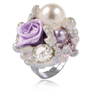 Détail d'une bague ajustable avec rose en ruban violet, perles et un grand strass brillant