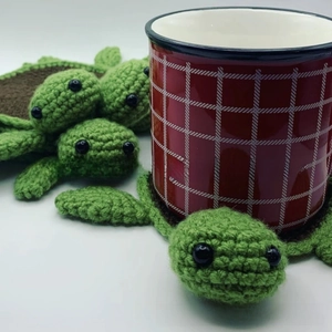 Close-up of green and brown hand-knitted turtle coaster with detailed crochet texture