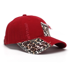 Detail of red distressed baseball cap featuring leopard print brim and metal adjustment buckle