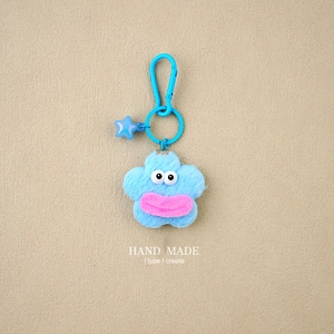 Detailed view of handmade blue plush flower keychain with star charm and carabiner clip