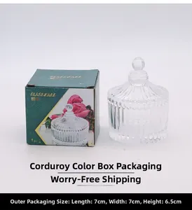 Close-up of ribbed crystal glass jar with sphere lid beside its floral green gift box
