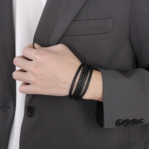 Close-up of men's multi-layer black braided leather bracelet with a steel magnetic clasp