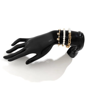Three-piece gold chain and faux pearl bracelet set displayed on a hand model