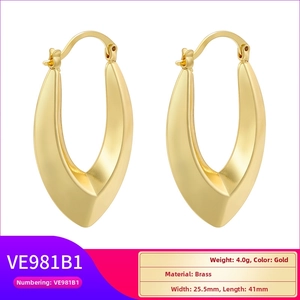 Macro view of gold-plated hollow C-shape earrings showing detailed brass texture and dimensions
