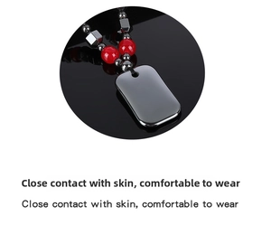 Detail of polished hematite pendant with red agate beads on a black reflective surface
