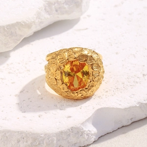 Detailed close-up of 18K gold plated flower ring with yellow zircon on white stone
