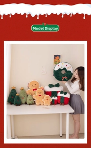 Christmas plush toy collection including gingerbread man and wreath held by a model