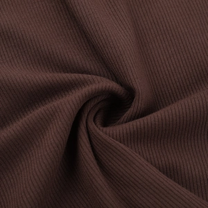 Gros plan sur la texture du tricot côtelé marron foncé montrant des plis doux et fluides