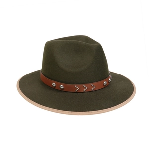Detail of dark green fedora hat featuring brown leather band and silver bull head studs