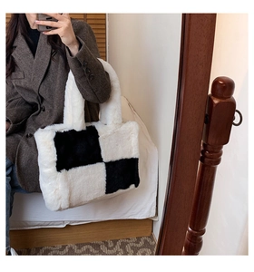 Detail of checkered faux fur tote bag held by a model in a mirror selfie