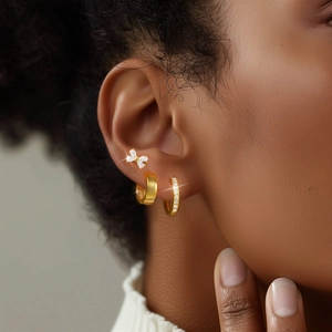 Detail of S925 sterling silver gold earring set featuring butterfly stud and hoop earrings