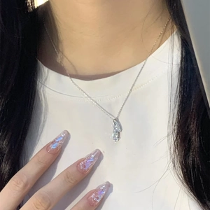 Detail of S925 silver necklace featuring a faceted teardrop crystal pendant worn by model