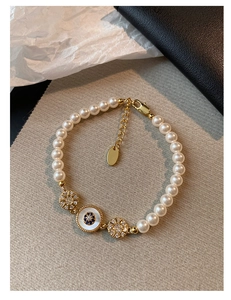 Vue détaillée d'un bracelet en perles plaqué or 18 carats avec breloques œil bleu