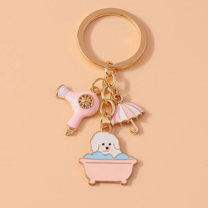 Close-up of a Bichon dog in a pink bathtub keychain charm with hairdryer and umbrella