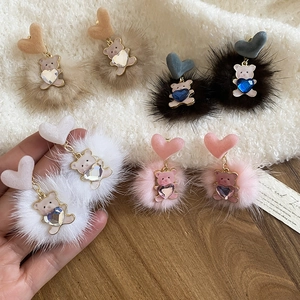 Detail of four pairs of plush bear earrings in khaki, brown, white and pink colors