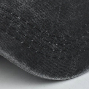 Detailed close-up of heavy-duty stitching on vintage washed cotton baseball cap brim