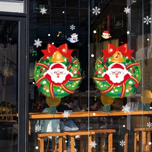 Christmas window stickers featuring Santa Claus wreaths and snowflakes on glass display