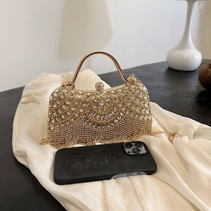 Sparkling gold rhinestone box handbag with chain strap shown next to a smartphone