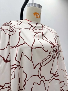 Detailed view of high-quality cream fabric with elegant red abstract floral print texture