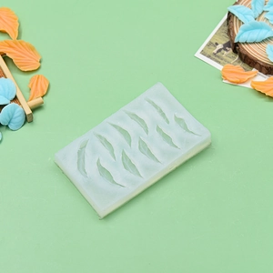 Detail of 10-cavity silicone leaf mold with finished orange and blue fondant decorations