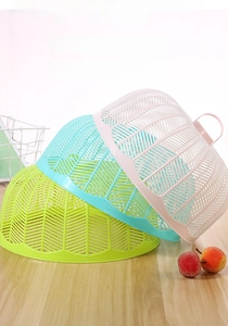 Detail of three stackable mesh food covers in pink blue and green for dining table safety