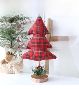 Detailed close-up of mini fabric Christmas tree with red plaid pattern and wooden base