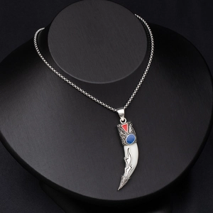 Close-up of vintage faux wolf tooth necklace with red and blue accents on a black bust