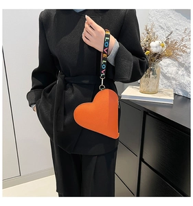 Détail du sac coeur orange en similicuir avec bandoulière large à motif LOVE