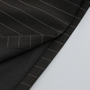 Close-up of premium black pinstripe fabric showing detailed weave texture and white stripes