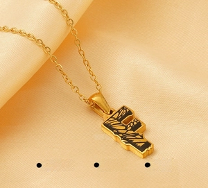 Macro shot of letter F pendant necklace in 18k gold plating over polished stainless steel