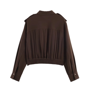 Détail de la veste courte marron foncé avec plis au dos et ourlet élastiqué à la taille