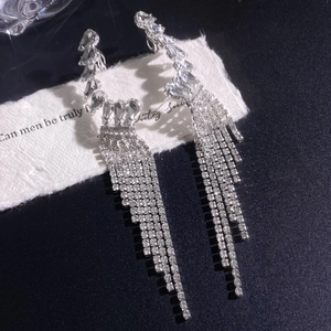 Macro shot of sparkling zircon tassel earrings with silver base and waterfall fringe
