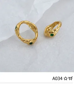 Detail of vintage gold ring with hammered lava texture and inlaid green zircons
