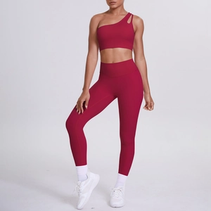Detail of burgundy one-shoulder sports bra and high-waist yoga leggings set for women