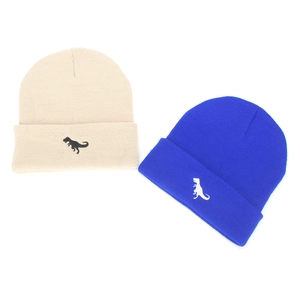 Detail of embroidered dinosaur pattern on beige and royal blue knit beanies