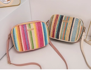 Detail of colorful rainbow striped straw crossbody bags with zipper and leather straps