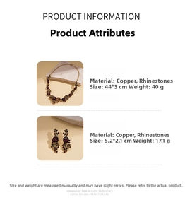 Close-up of vintage bronze leaf necklace and earrings set with deep red rhinestones
