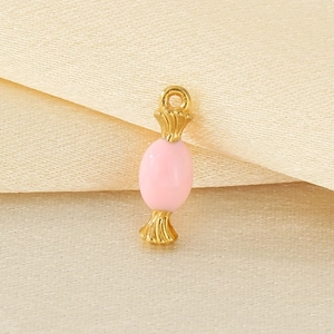 Pink enamel candy pendant in 18K gold plated stainless steel on beige fabric