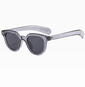 Close-up of translucent grey oval sunglasses showing temple model specs and black lenses
