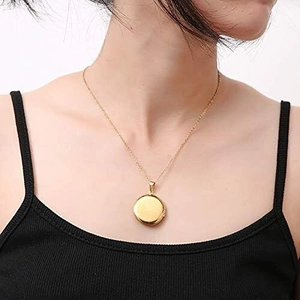 Elegant gold round locket necklace on model featuring a polished stainless steel finish