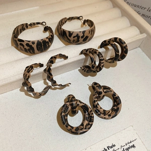 Macro view of five pairs of vintage leopard print hoop earrings on jewelry tray