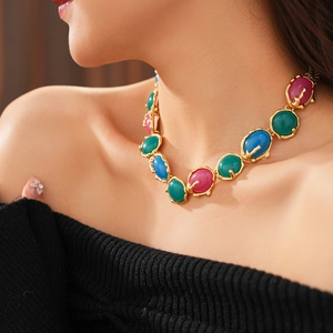 Détail du collier vintage avec pierres ovales colorées sur chaîne en métal doré