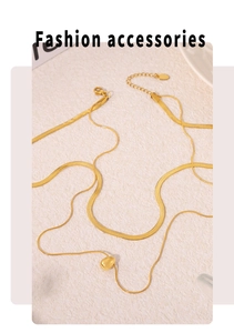 Close-up of a layered gold necklace set with snake chain and round bead pendant