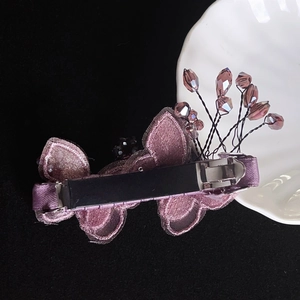 Détail d'une barrette papillon violette avec broderie élégante et cristaux brillants