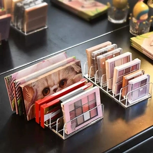 Clear acrylic makeup organizer for eyeshadow palettes and cosmetics on a desktop