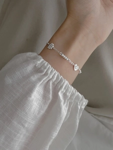Close-up of S925 sterling silver pretzel bracelet with heart charms on model wrist